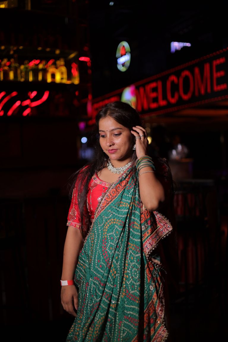 Couple in traditional wedding outfits seated together in soft indoor lamp light in Noida