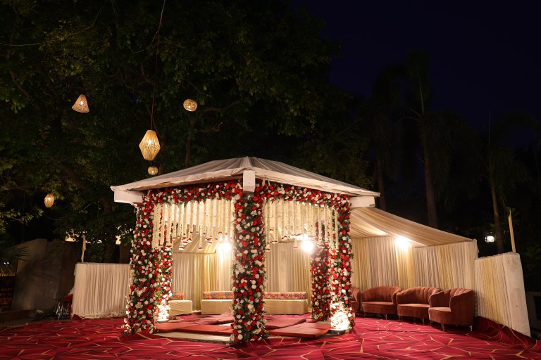 Wedding stage lit up at night at a farmhouse function in Noida