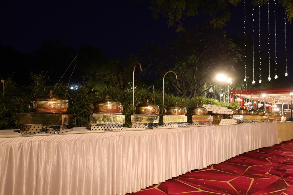 Counters and dining setup on the lawn at night at a wedding near NH-24