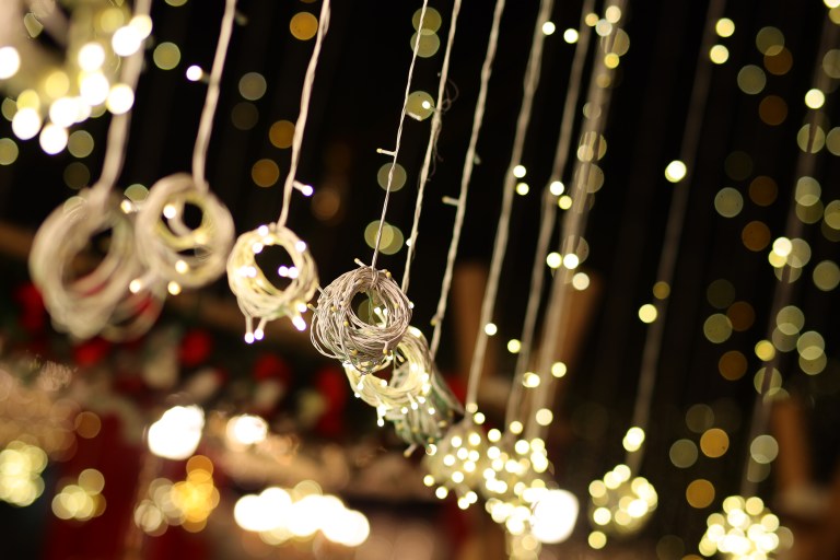 Hanging lanterns and fairy lights above a farmhouse wedding lawn
