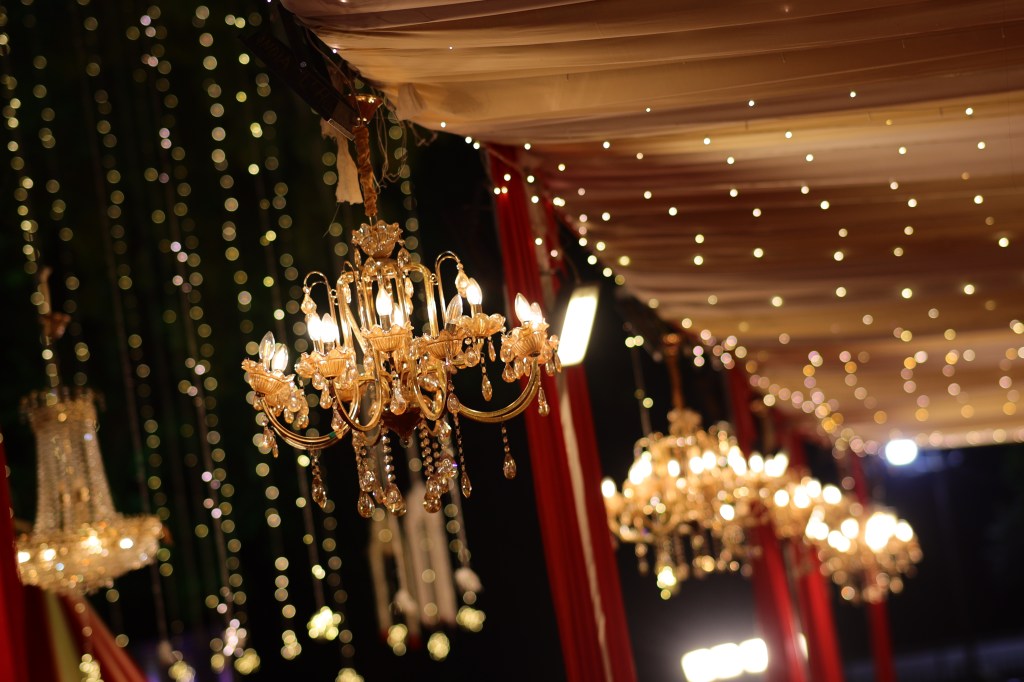 Chandelier with fairy lights and drapes at a celebration in Noida by Mithila Events