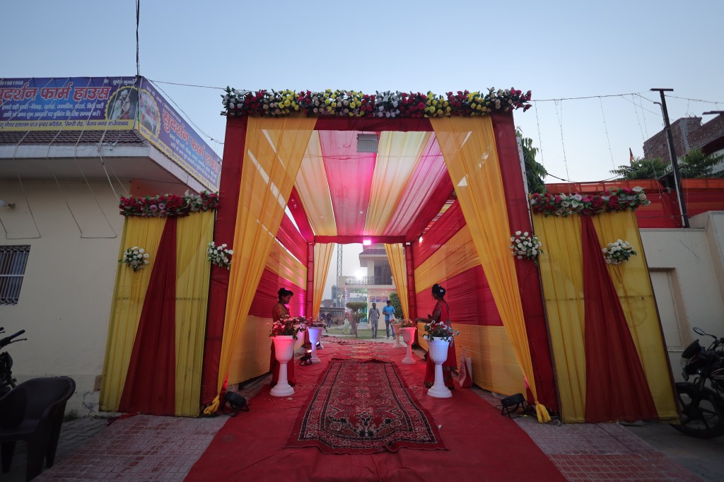 Pink and gold draped entrance passage at a wedding venue in Noida