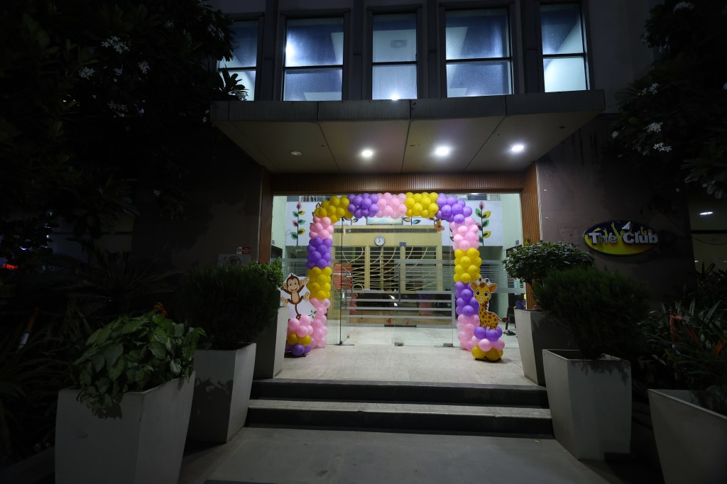 Banquet venue entrance at night with a pink, purple and gold balloon arch for a birthday party by Mithila Events