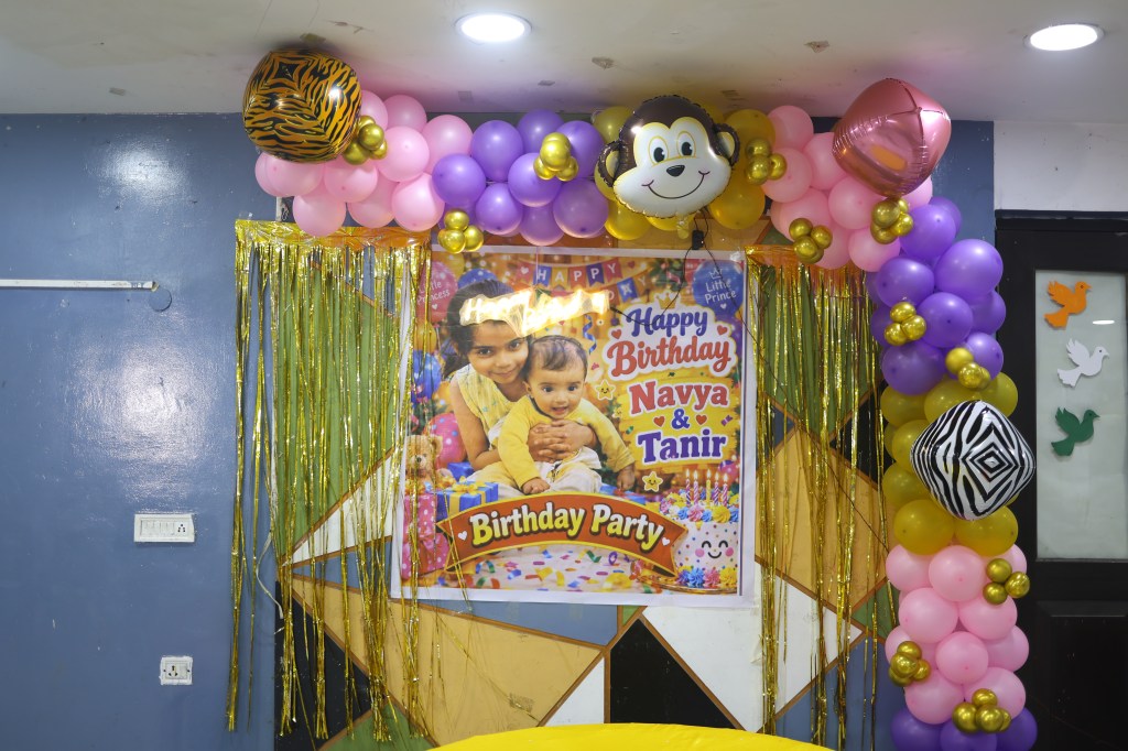 Birthday stage backdrop with the birthday baby's photo board and pink, purple and gold balloons by Mithila Events, Noida Extension