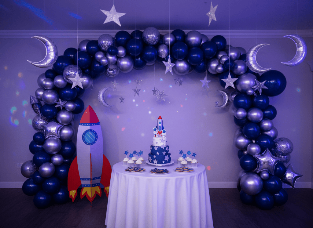Space theme birthday decoration with rocket cutout and planet balloons
