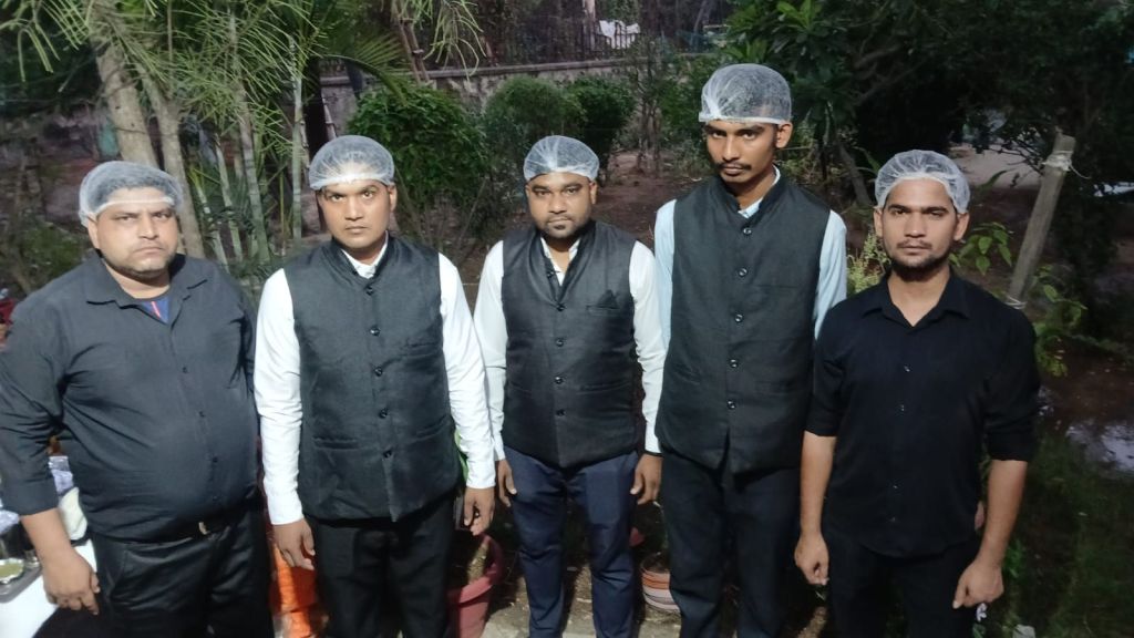 Mithila Events service team of five in black uniforms and hairnets ready before a catering event in Noida